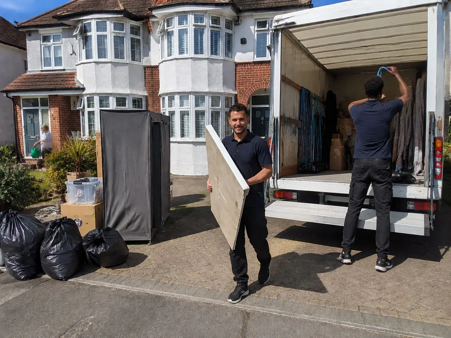 Movers unloading a Luton van outside a suburban home - Home Removal Services